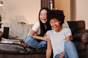 ADHD and Friendships: Challenges, Strengths, and How to Build Lasting Bonds 6 Two friends sat in a lounge together laughing and being playful.