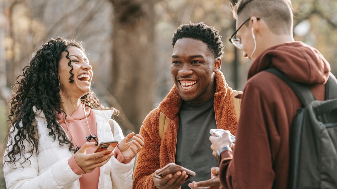 A group of adult friends outside laughing together.